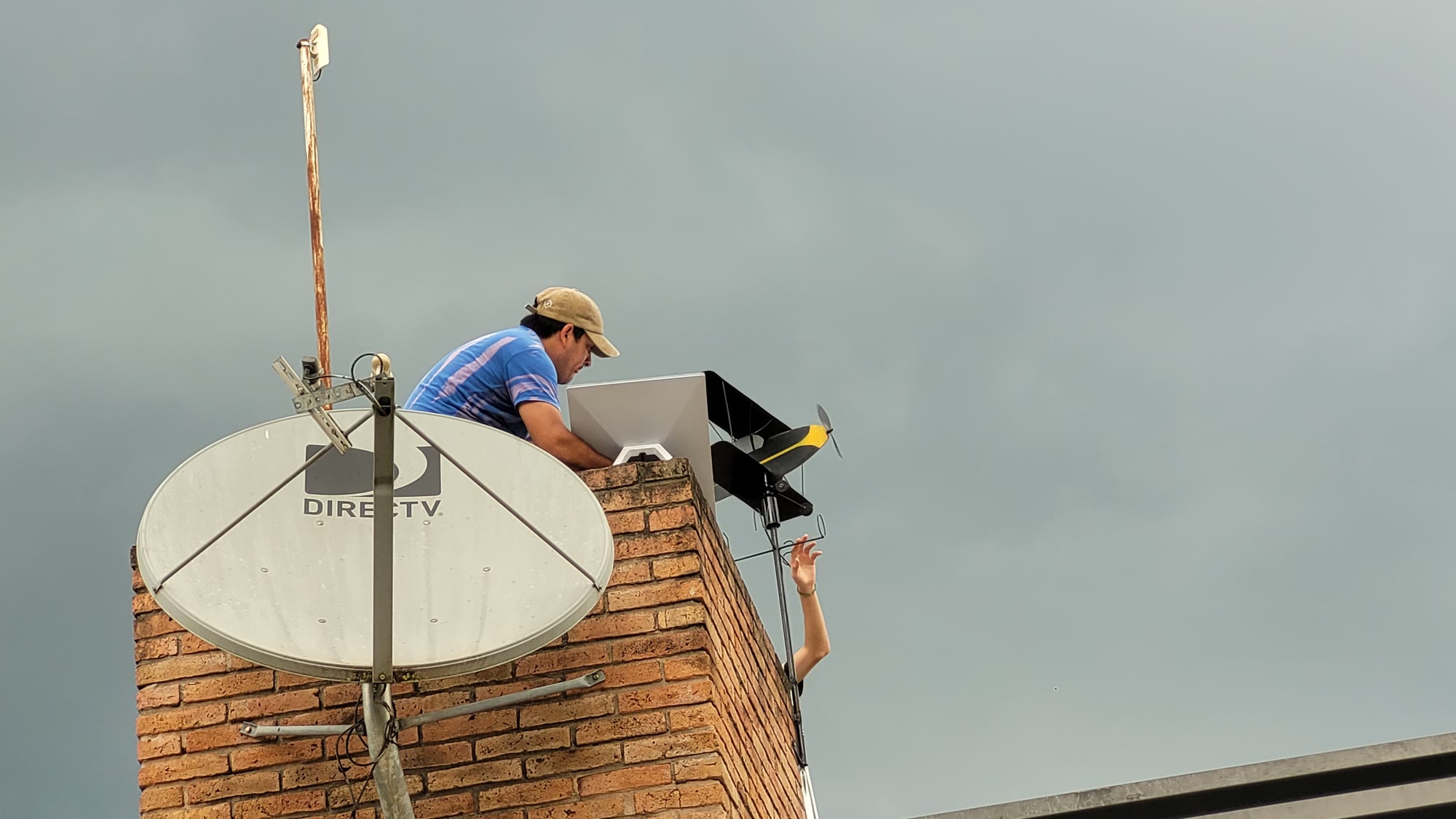 A Starlink flat dish installed on a rooftop next to an old geostationary DirecTV dish in Argentina