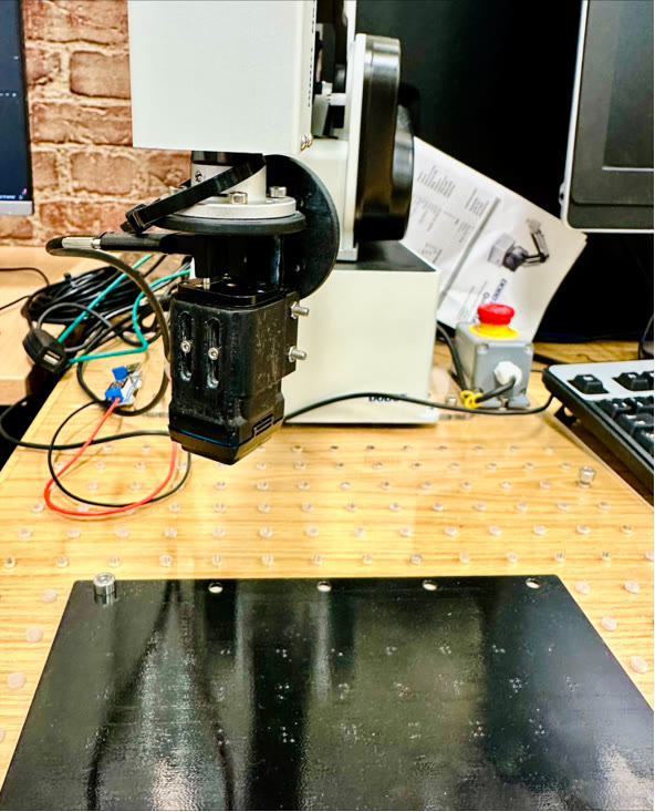 Robot arm with the Evetac tactile sensor above a 3D-printed Braille board