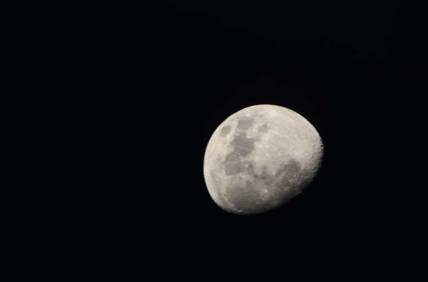 A bright waxing gibbous Moon against a black sky